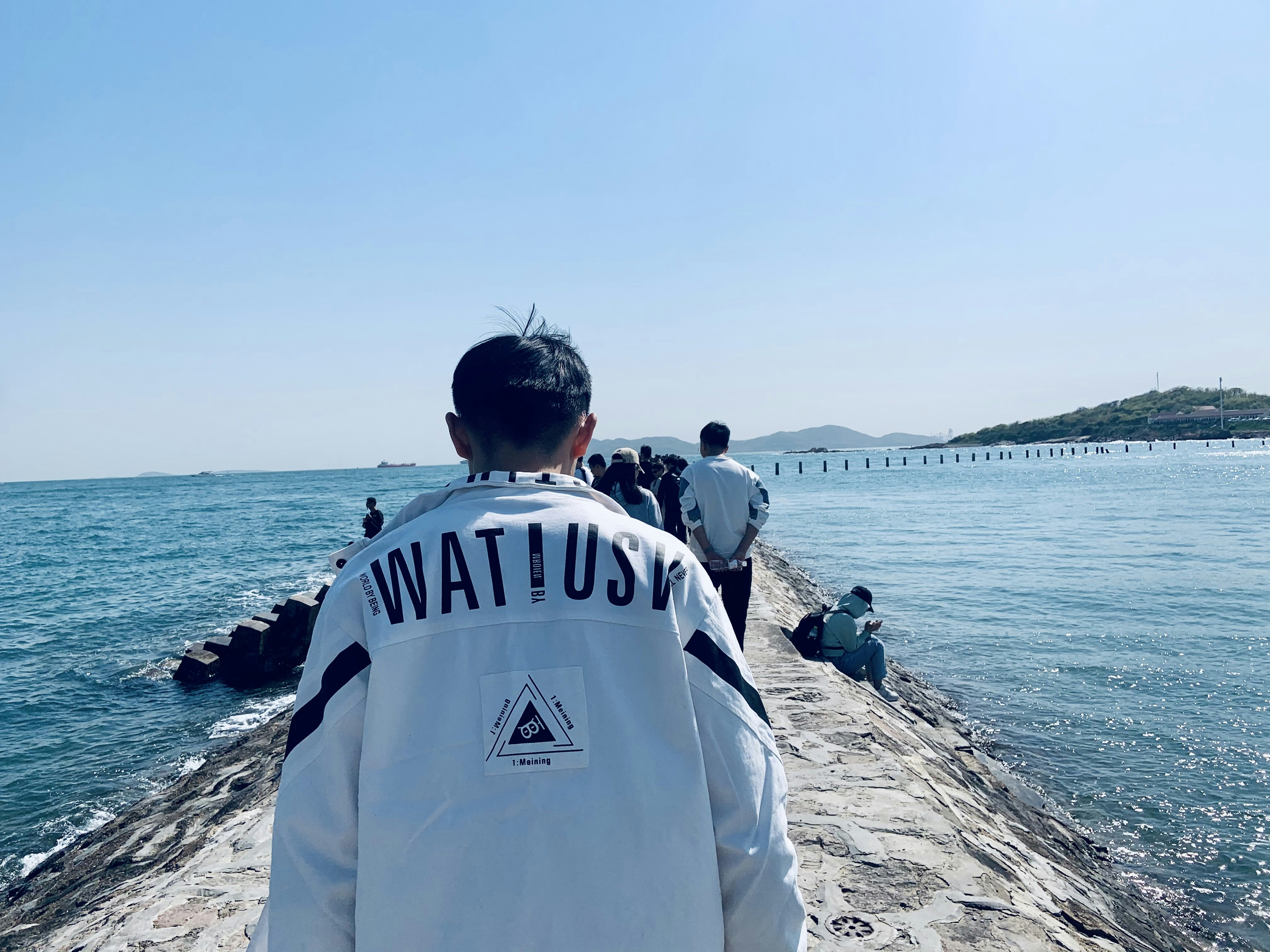 a man standing on top of a pier next to the ocean
