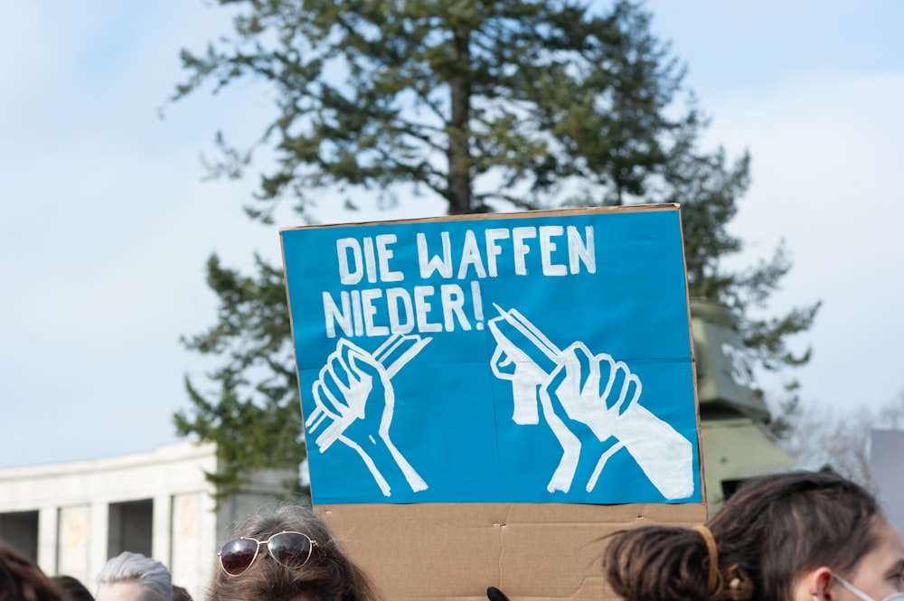 a group of people standing around a blue sign