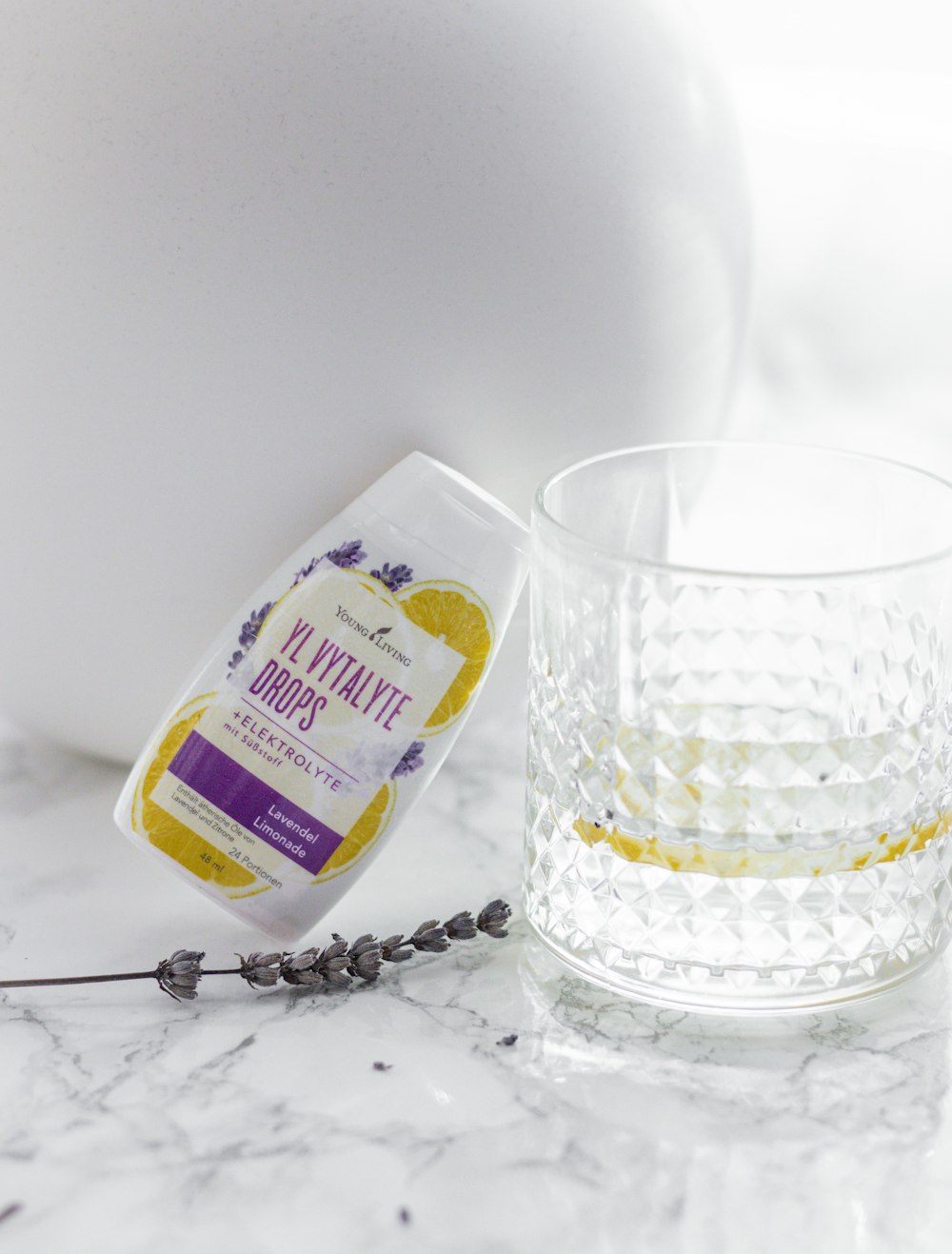 a glass of water next to a bottle of soap