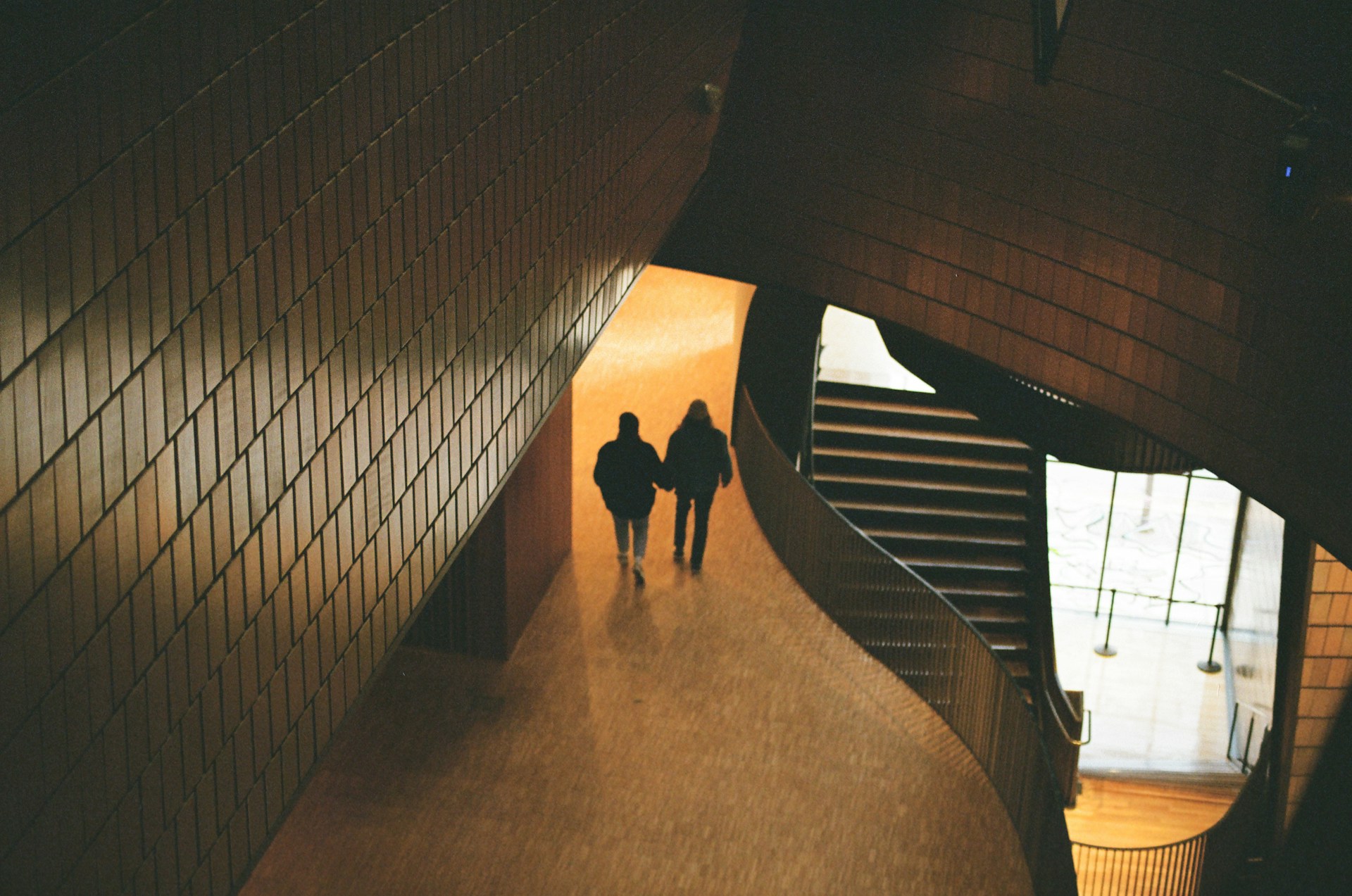 a couple of people walking down a hallway