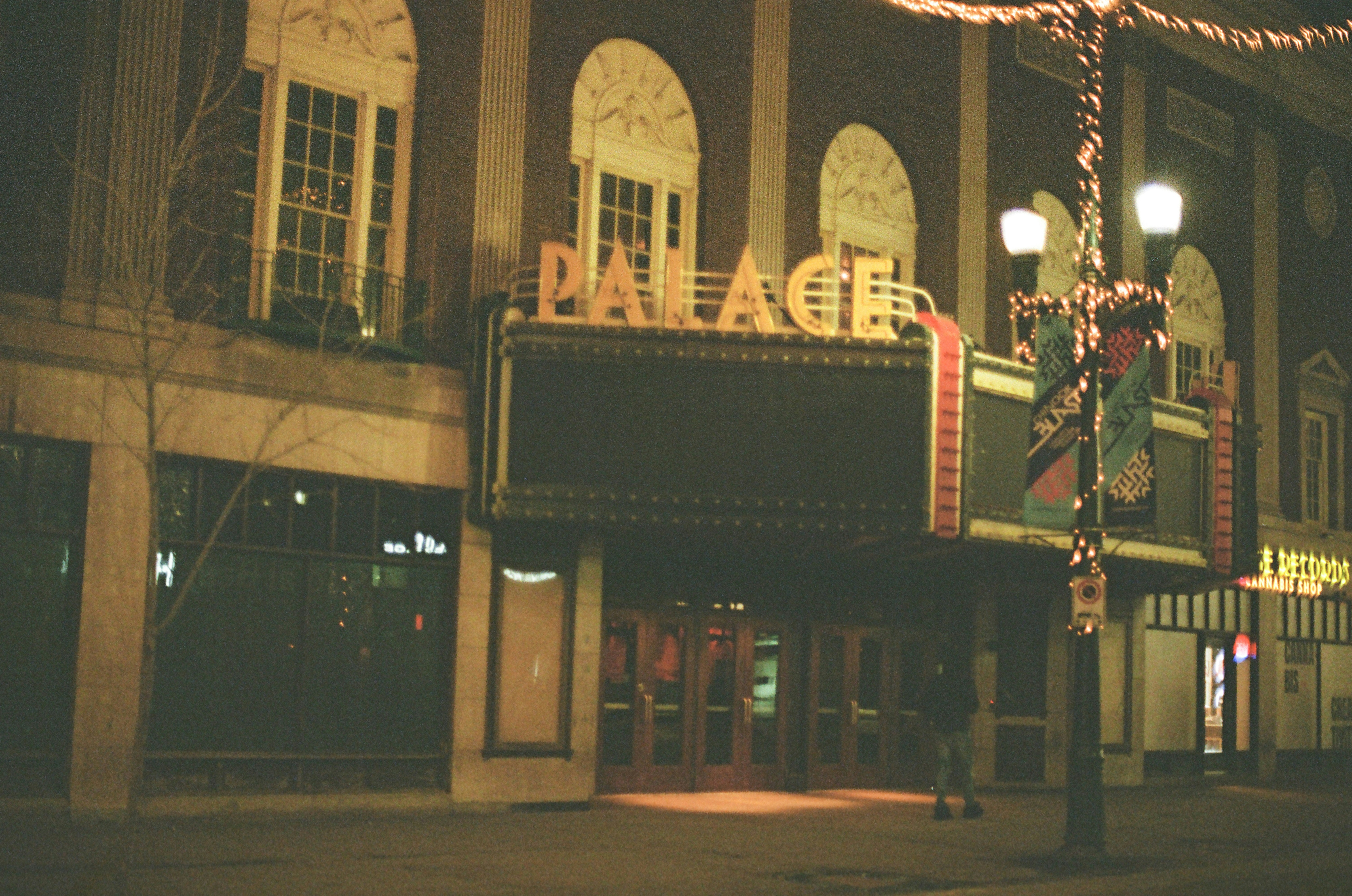 a movie theater is lit up at night
