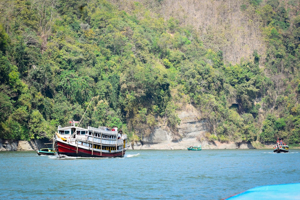 Ein Boot, das einen Fluss entlang neben einem üppigen grünen Hügel fährt