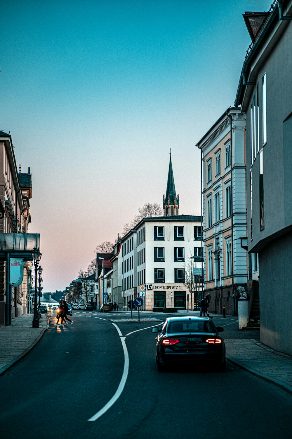 a car driving down a street next to tall buildings