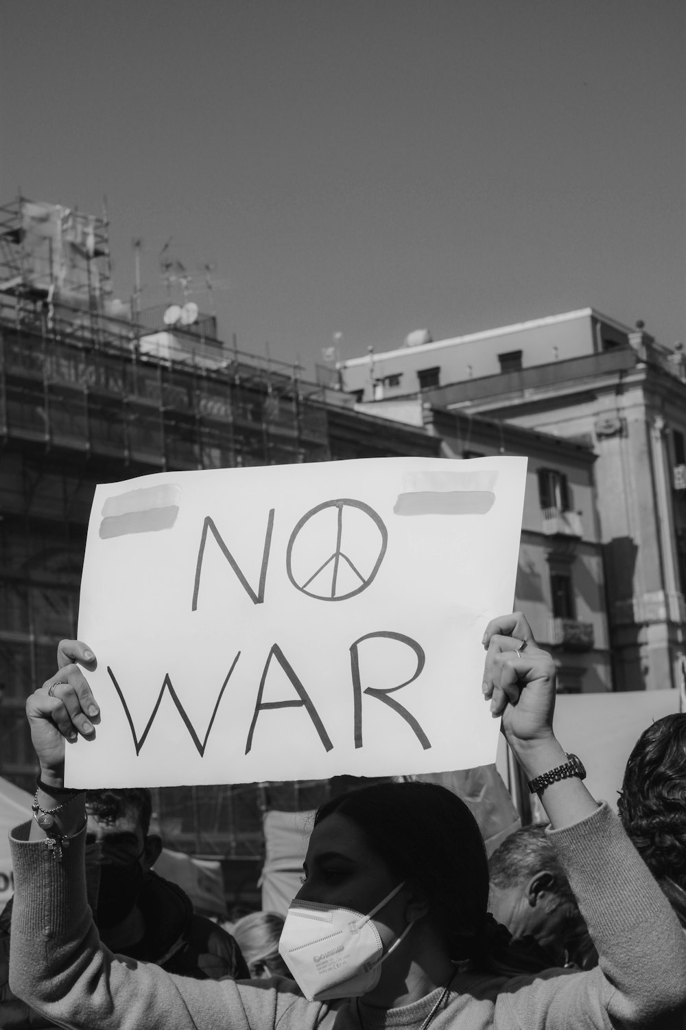 a group of people holding a sign that says no war