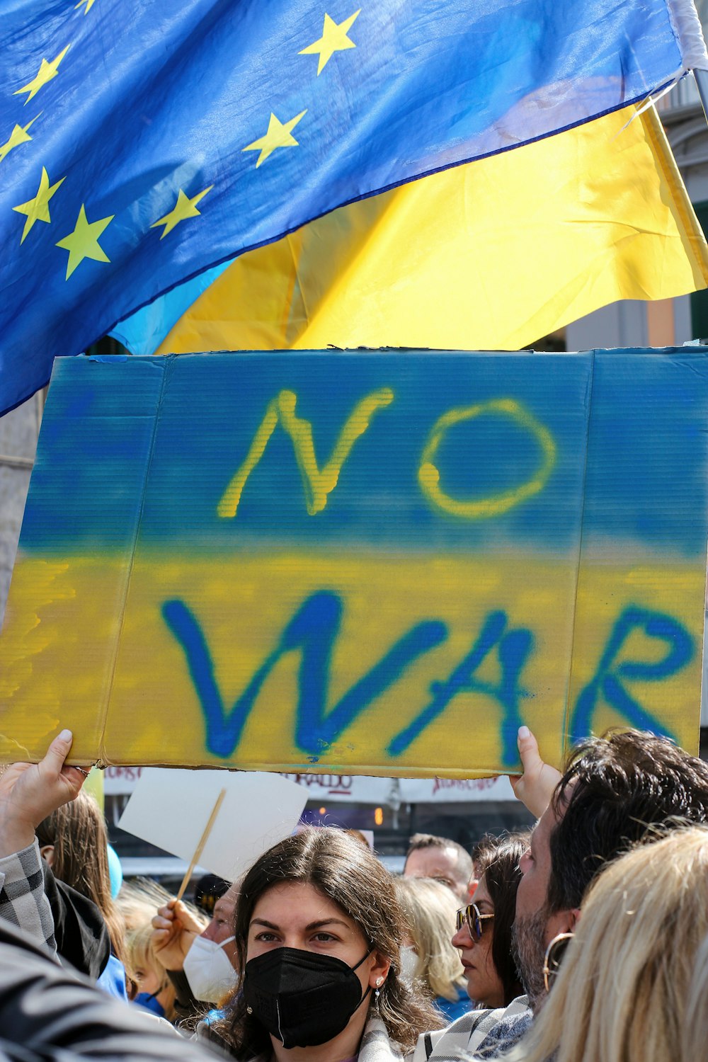 a woman holding a sign that says no war