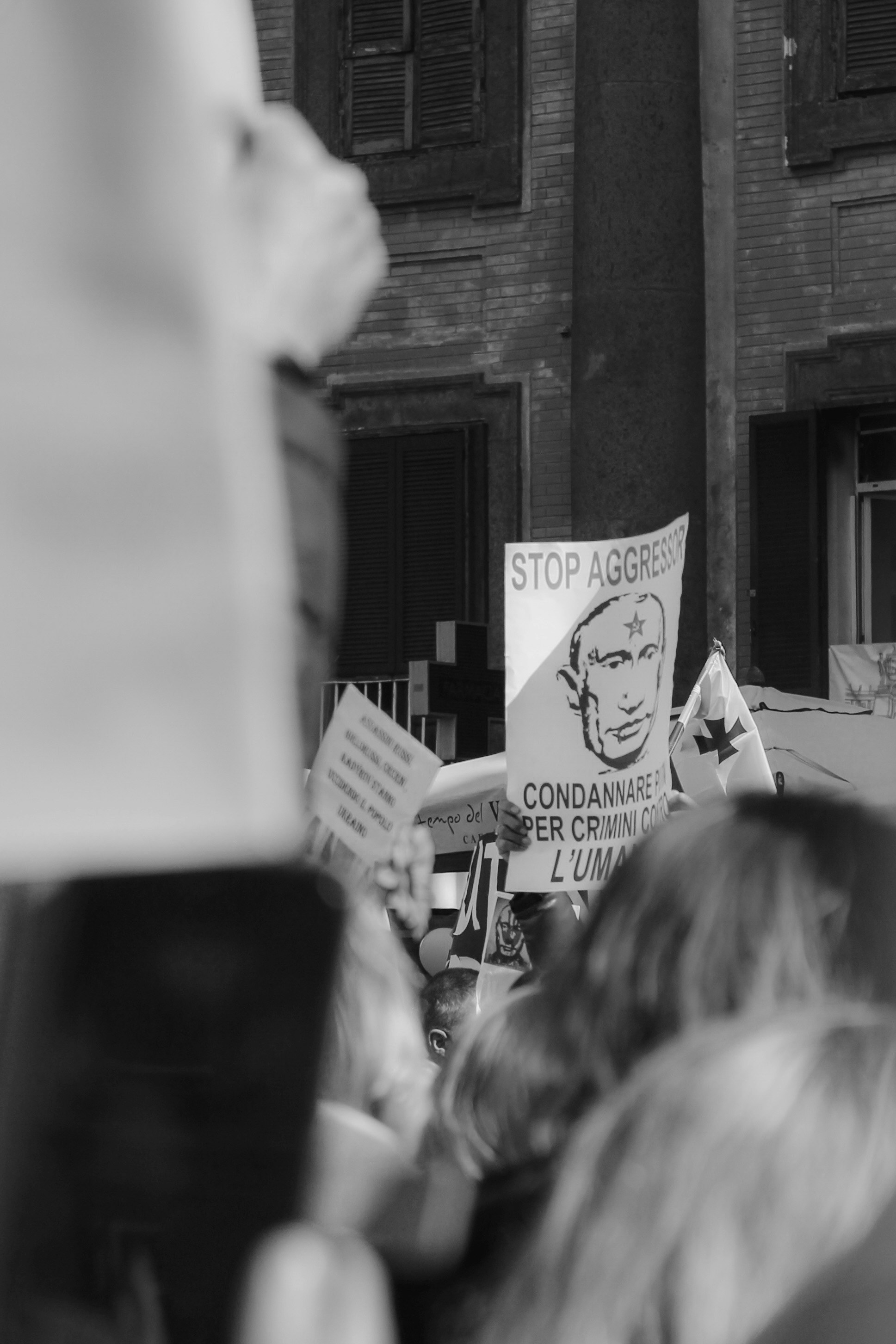 a group of people holding up signs in front of a building