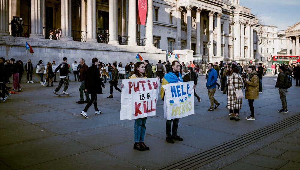 Un gruppo di persone con cartelli di protesta davanti a un edificio