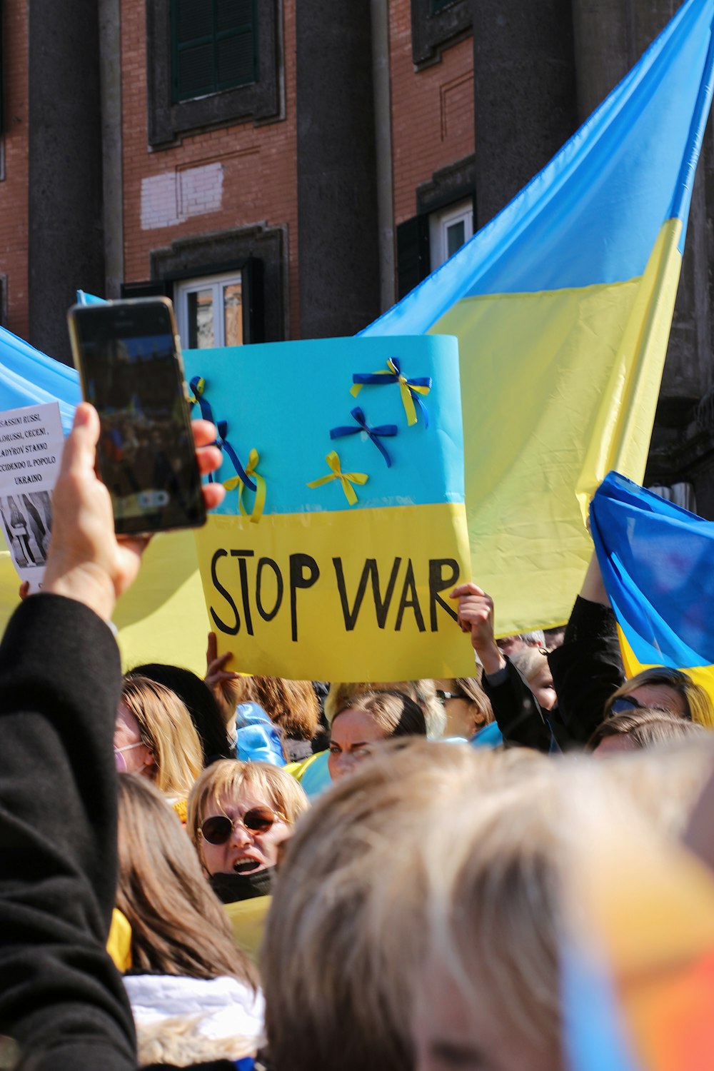 a crowd of people holding up signs and cell phones