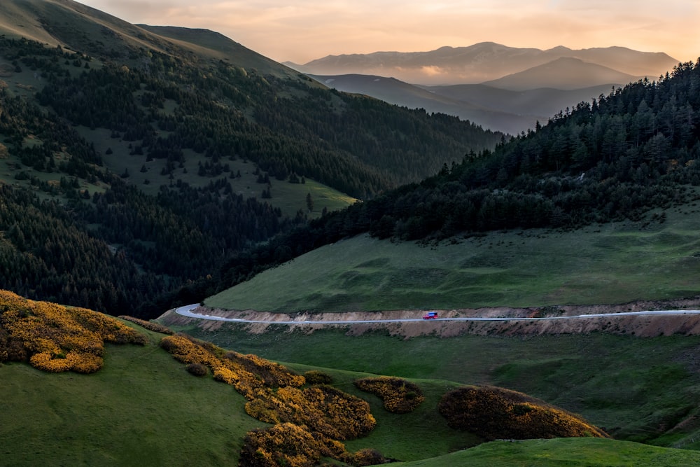 a car driving down a winding road in the mountains