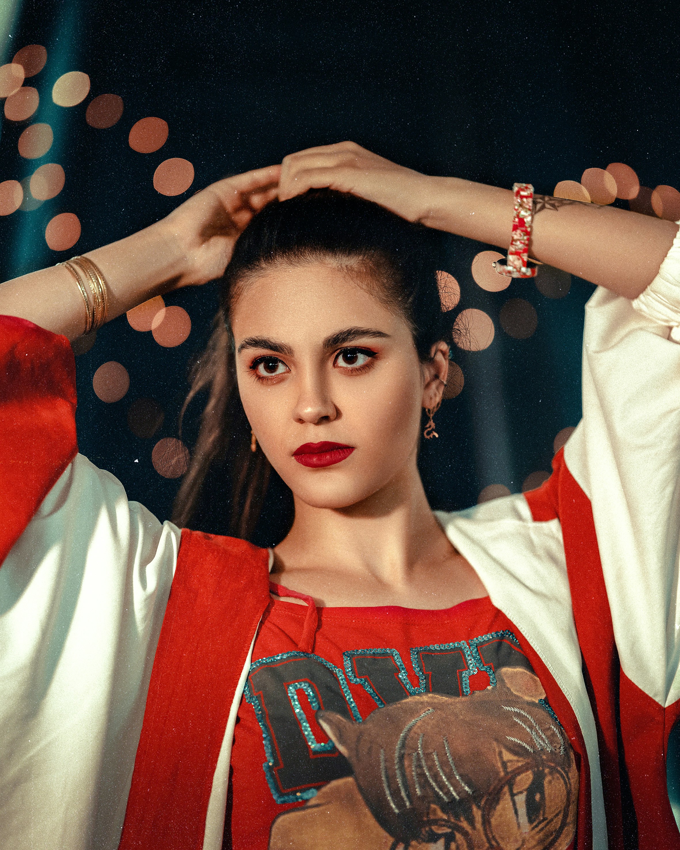 a woman in a red and white top is holding her hands on her head