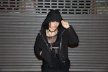 Editorial shot of layered gothic-inspired streetwear with dramatic shadows.