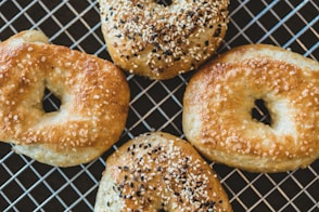 four bagels with sesame seeds on a cooling rack