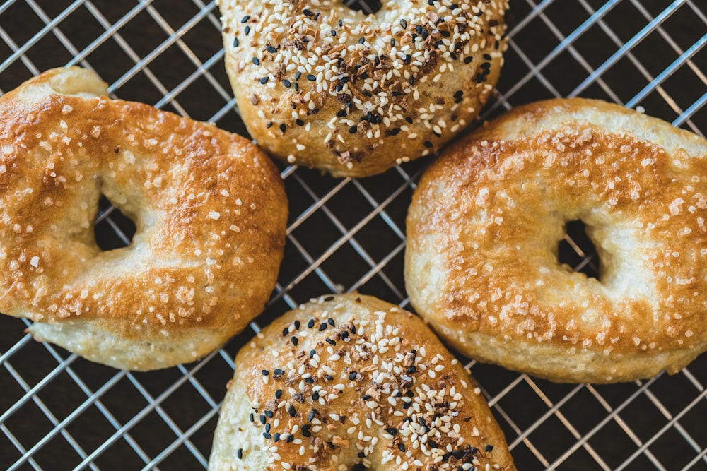 four bagels with sesame seeds on a cooling rack
