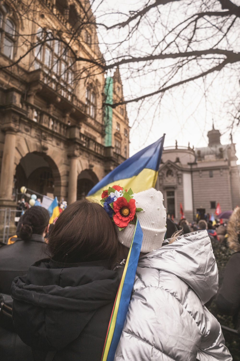 a woman with a flower in her hair standing in front of a building