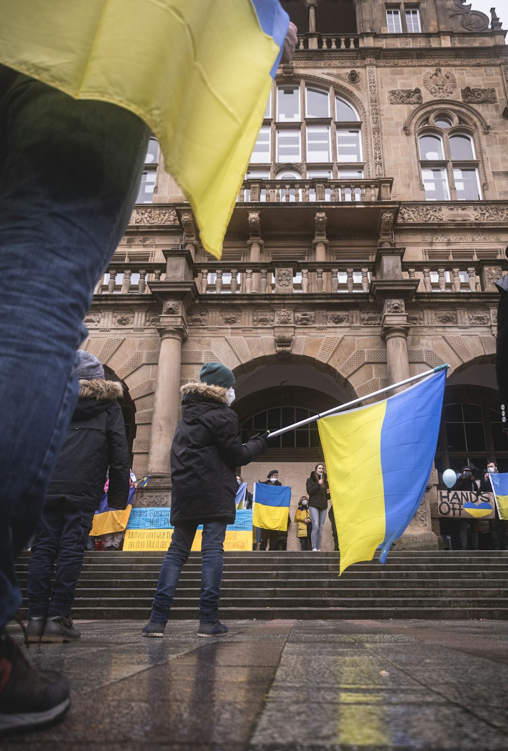 a group of people holding flags in front of a building