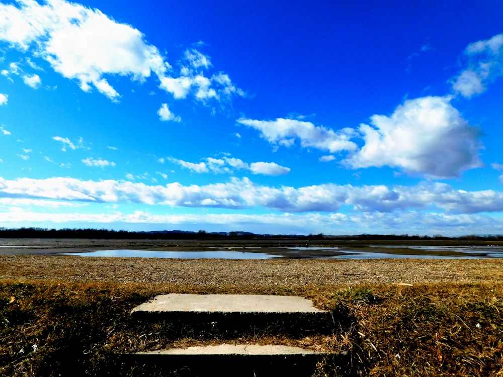 a bench sitting on top of a grass covered field