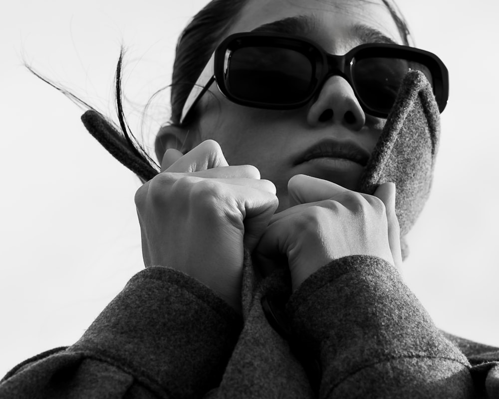 a woman wearing sunglasses holding a cell phone to her ear