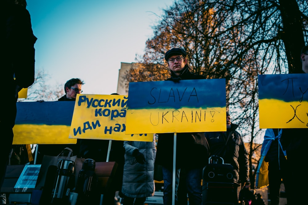 a group of people holding signs with writing on them