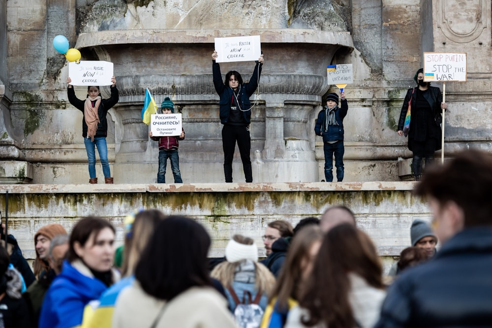 a group of people holding signs in front of a fountain