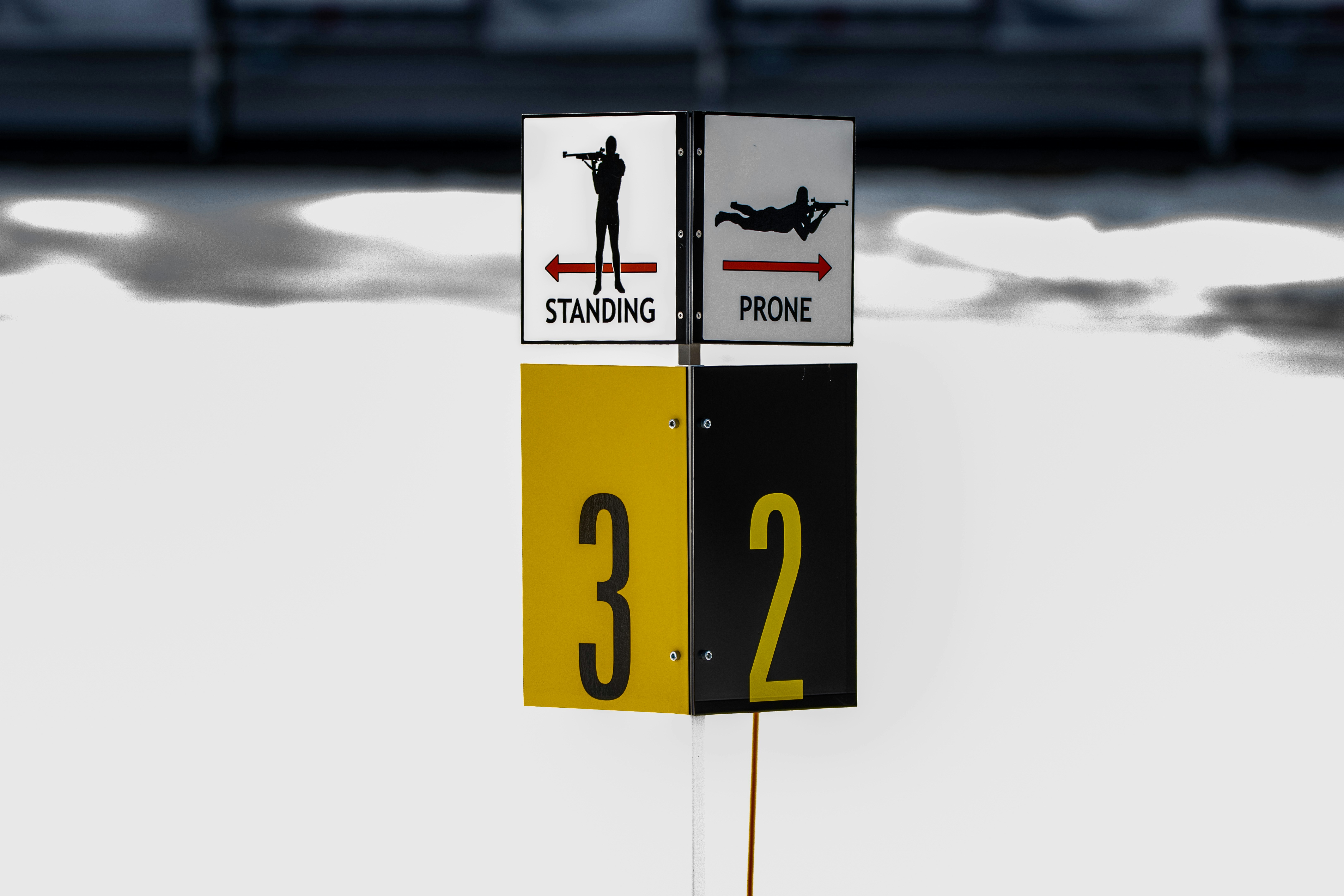 a street sign with a man standing on top of it, biathlon range Craftsbury Outdoor Center