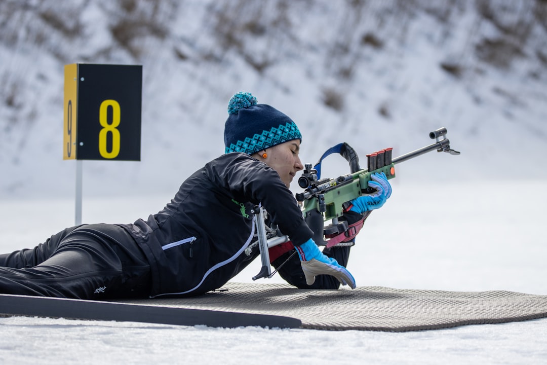 biathlon getting into position prone shooting with biathlon rifle, biathlon competition nordic skiing