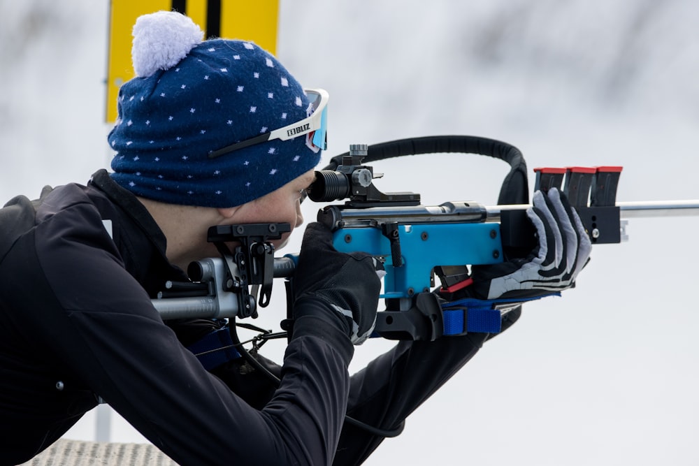 a man in a blue hat is aiming a bow