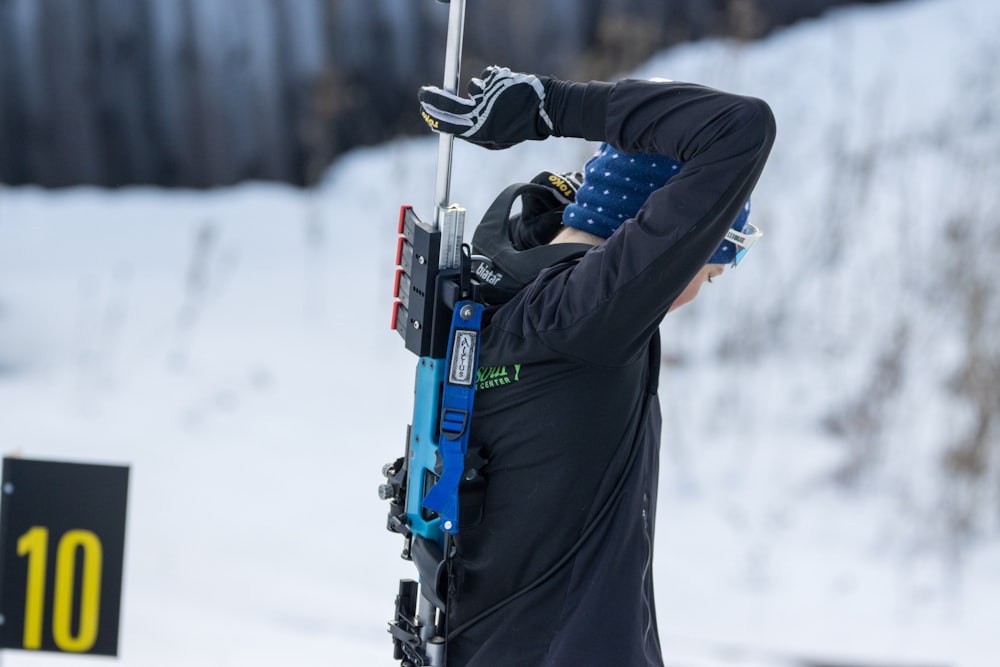 um homem segurando um poste de esqui na neve