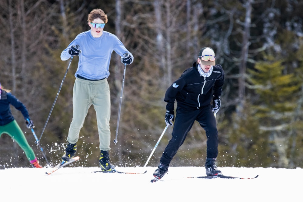 a group of people riding skis down a snow covered slope