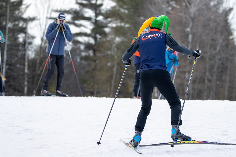 Eine Gruppe von Leuten, die auf Skiern einen schneebedeckten Hang hinunterfahren