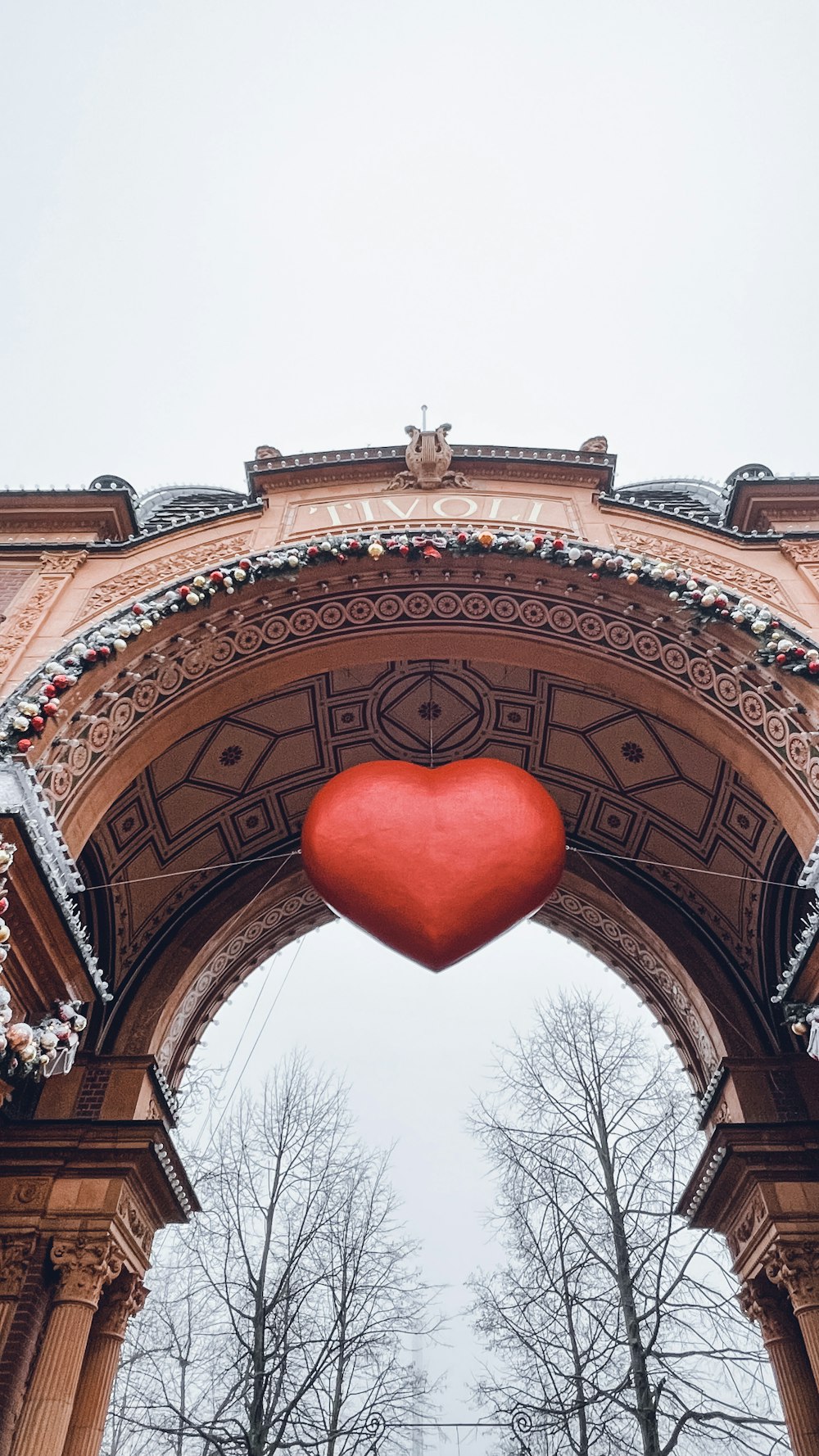 a large red heart hanging from the side of a building