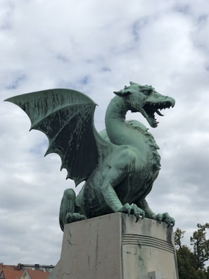 a statue of a green dragon on a pedestal