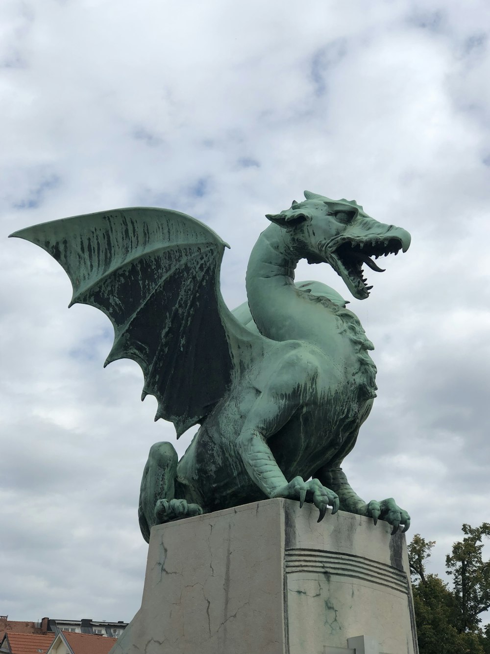 Una estatua de un dragón verde en un pedestal