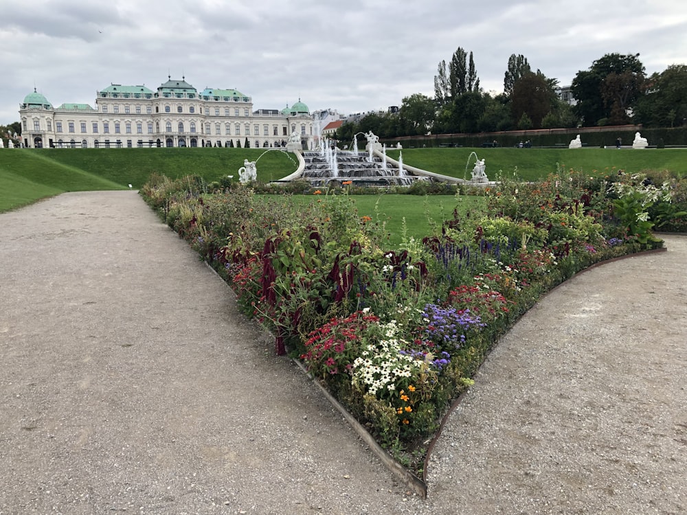 a large white building with a garden in front of it