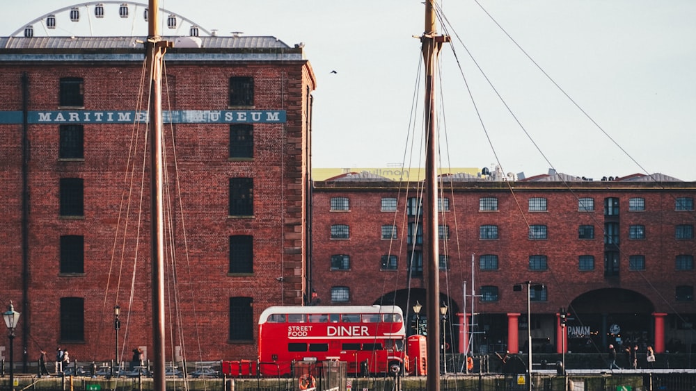 Ein roter Doppeldeckerbus parkt vor einem Gebäude