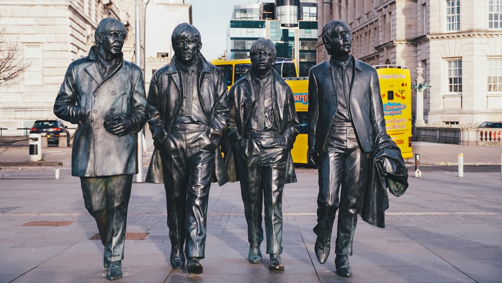 a group of statues of three men standing next to each other