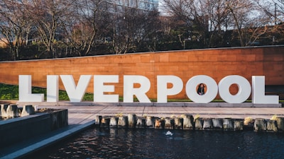 a large sign that says liverpool next to a body of water