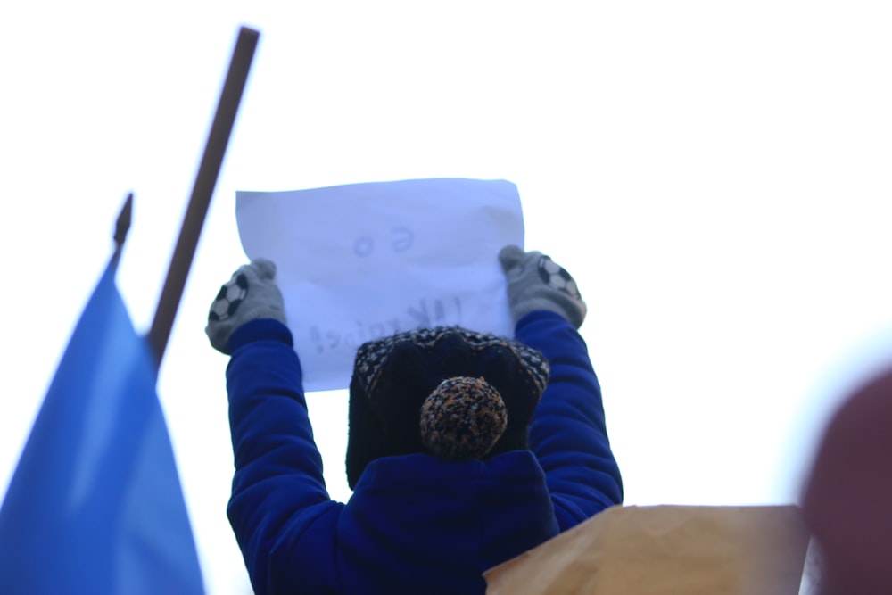 a person holding a piece of paper above their head
