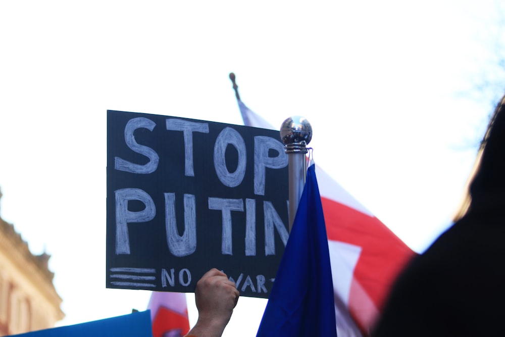 a person holding a sign that says stop putting no war