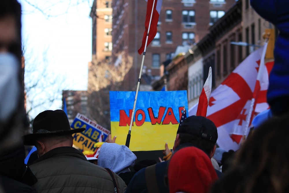 a crowd of people holding signs and flags