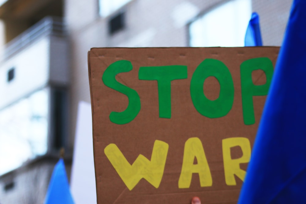 a person holding a sign that says stop war