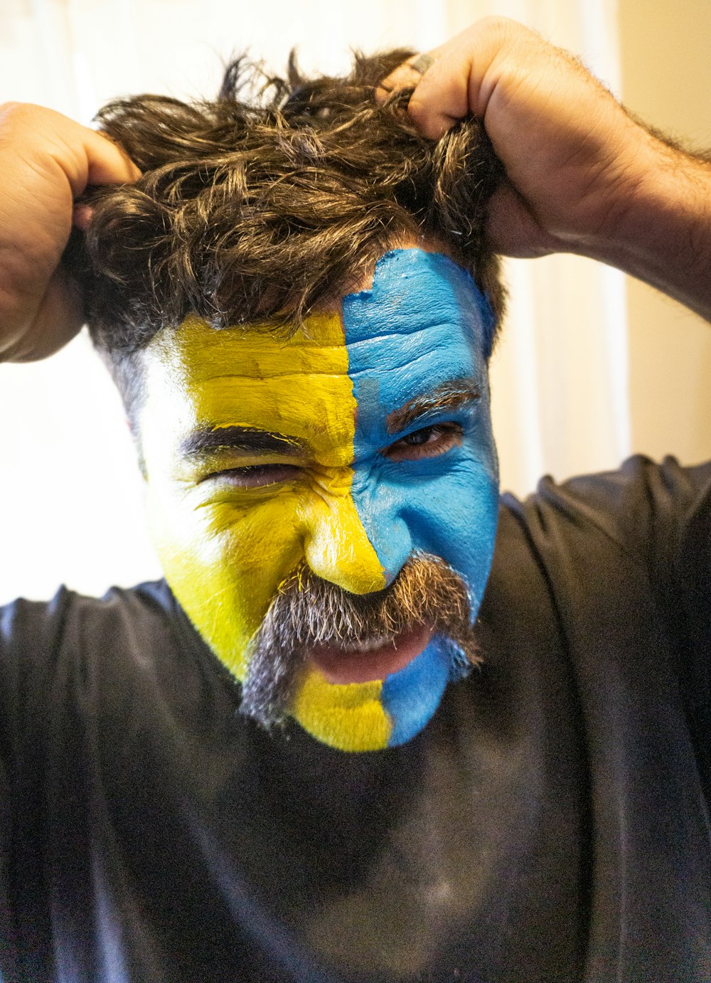 a man with his face painted in the colors of the swedish flag