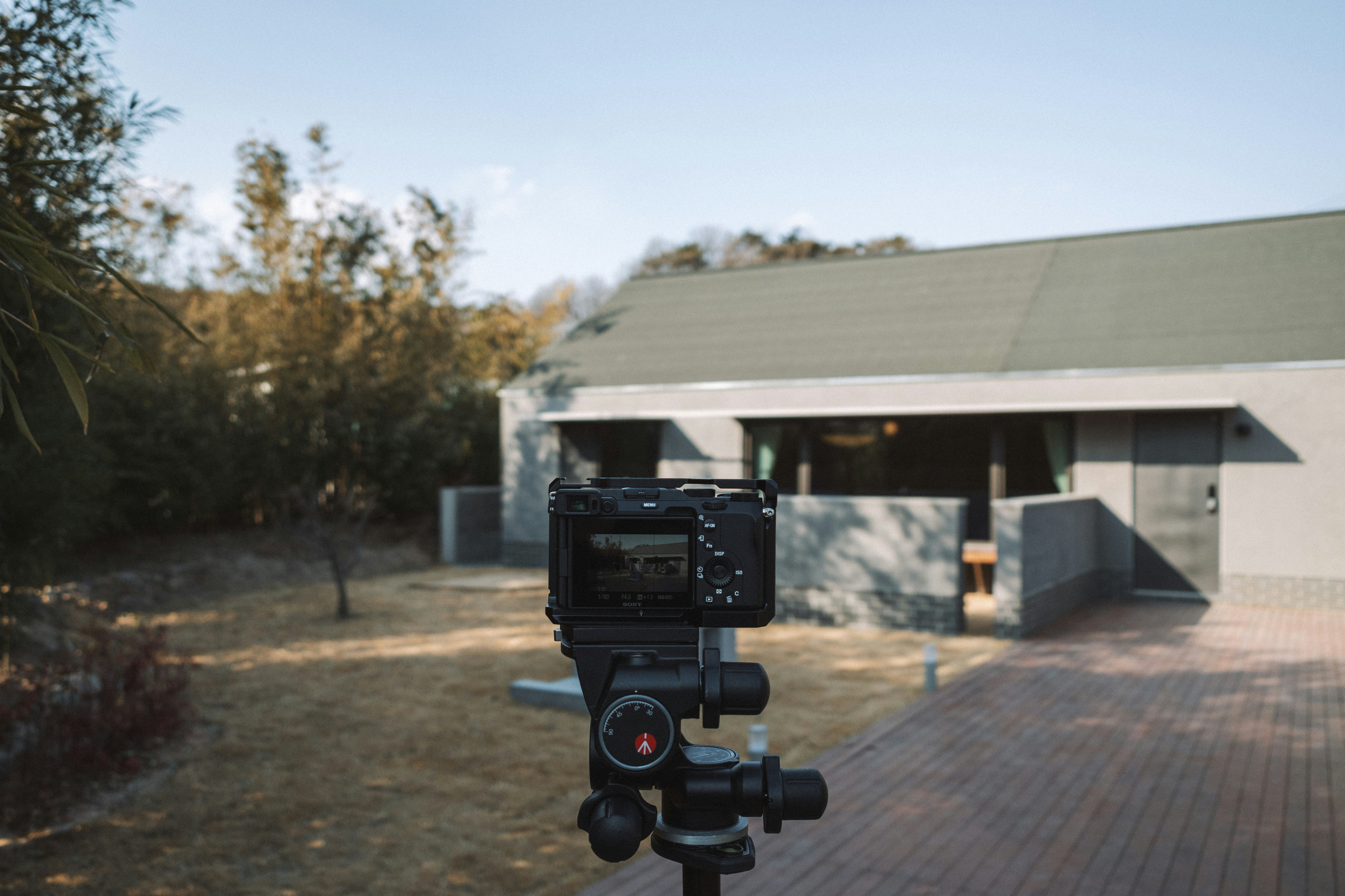 un trépied avec une caméra attachée devant une maison