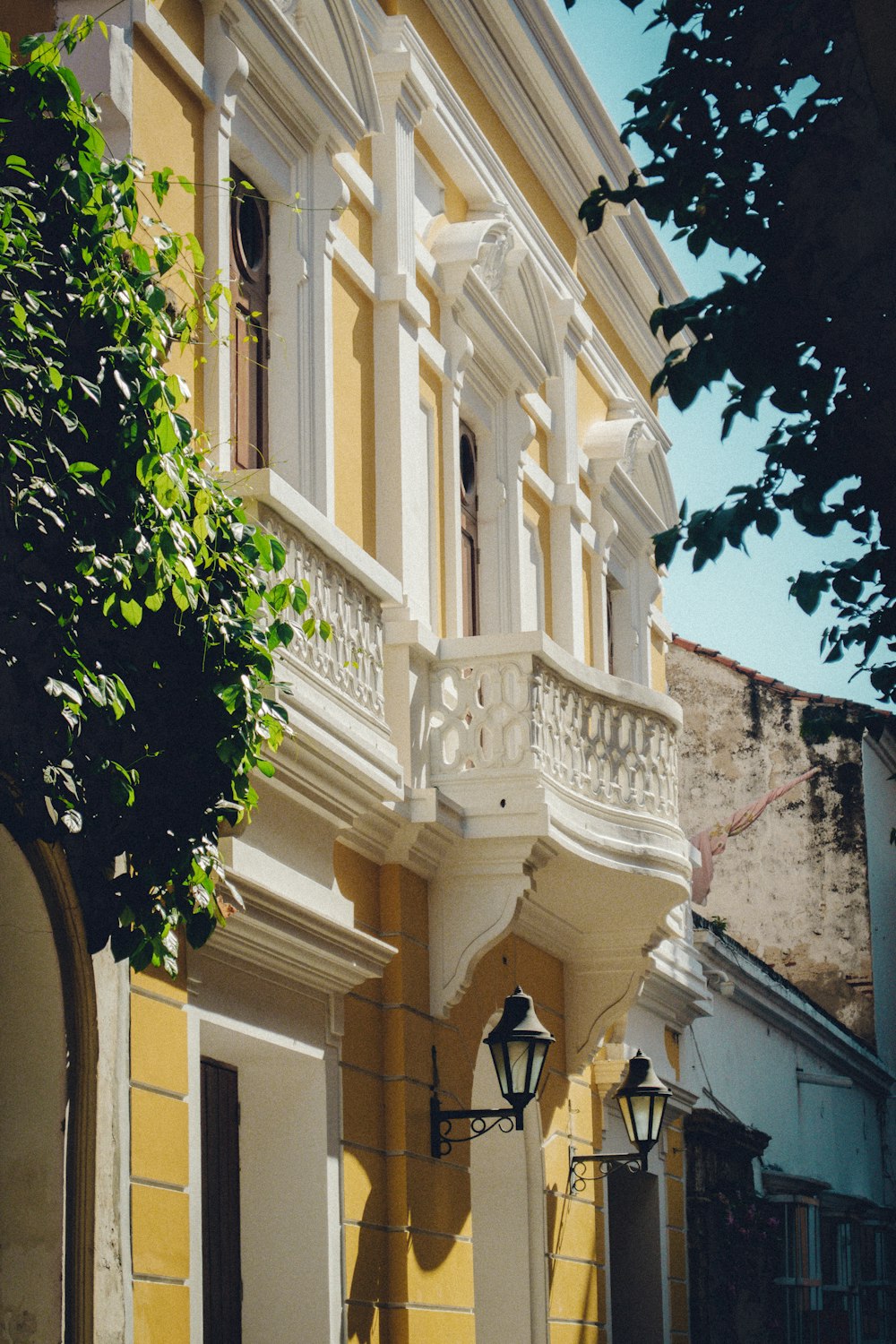 Un edificio amarillo con balcones blancos y un reloj