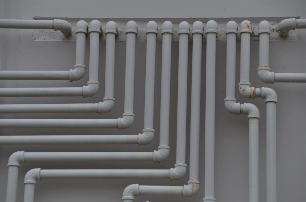 A wall of neatly run supply pipes and elbows in a commercial building.