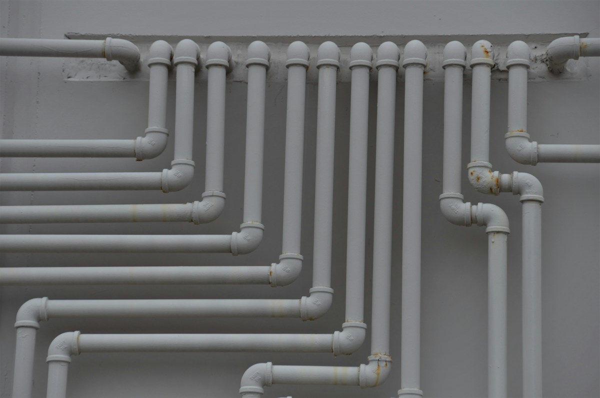 White PVC pipe runs on a wall
