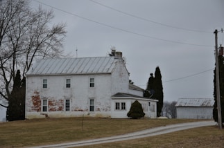 a large white house sitting on top of a lush green field