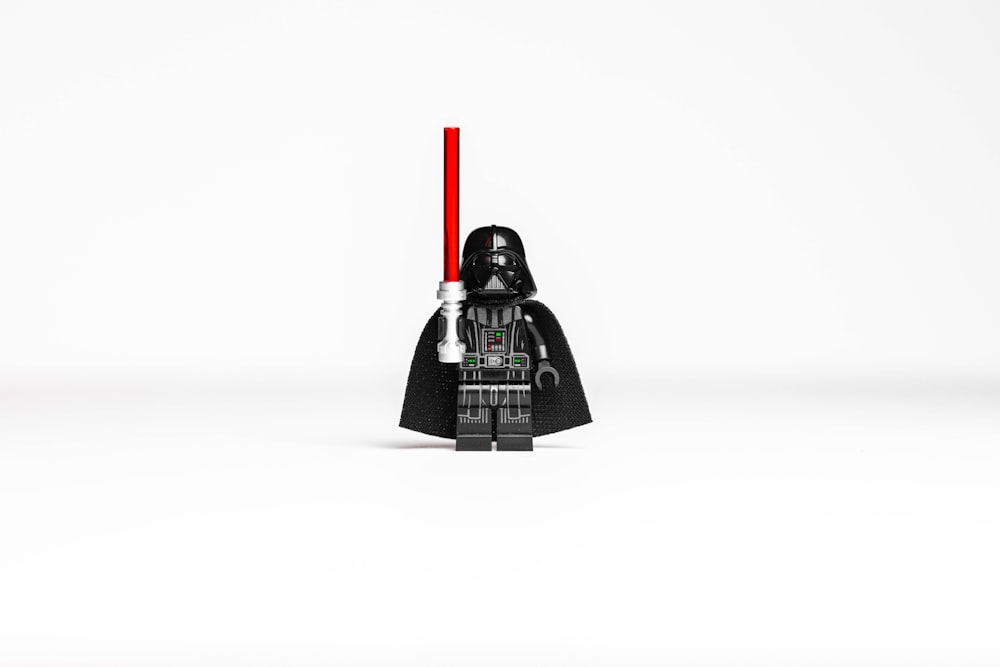 a lego darth vader with a red light saber