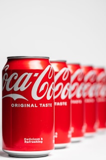 a row of coca - cola cans sitting next to each other