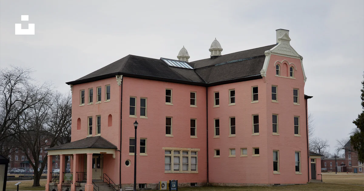 Pink Building Frame A large pink building with a black roof photo – Free Building Image on ...