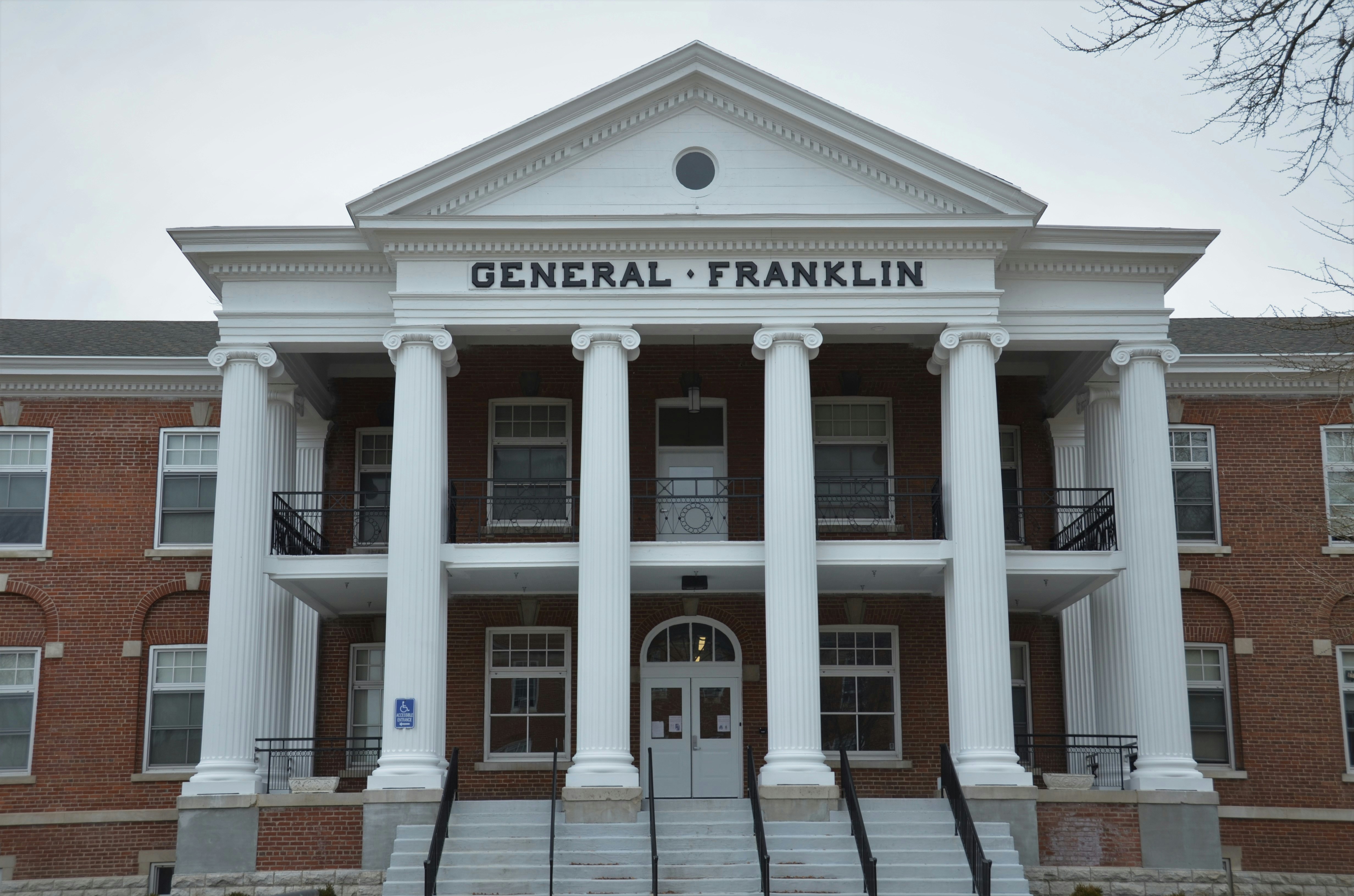 the front of a brick building with columns